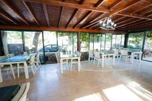 a dining room with tables and chairs and windows at Kutberk Hotel Kemer in Kemer