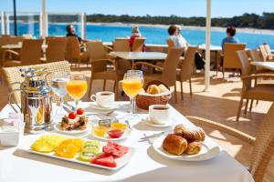 a table with breakfast food and drinks on a balcony at Universal Casa Marquesa in Colònia de Sant Jordi