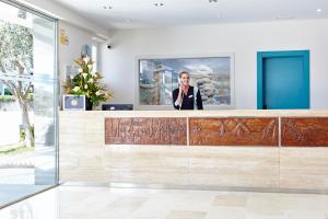 a woman talking on a cell phone in a lobby at Universal Casa Marquesa in Colònia de Sant Jordi
