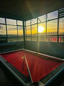 a pool table in a room with a view of the sunset at Stylish Ngong Retreat with Balcony & Rooftop Lounge The Moon Stays in Ngong