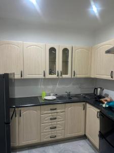 a kitchen with wooden cabinets and a black counter top at JH Guest house in Durban