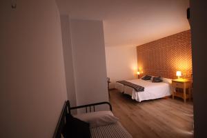 a bedroom with a bed and a table with a chair at Apartamentos La Rocanda in Coca
