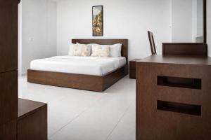 a bedroom with a bed and a dresser in a room at Hotel Murex in Brazzaville