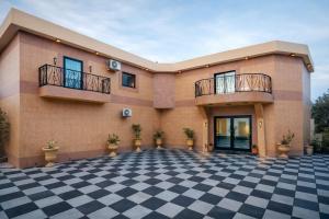 a building with a checkered floor in front of it at Hotel Murex in Brazzaville