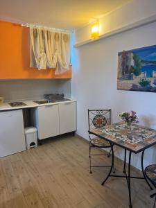 a kitchen with a table and a sink and a table at B&B Villa Jasiga in Fregene