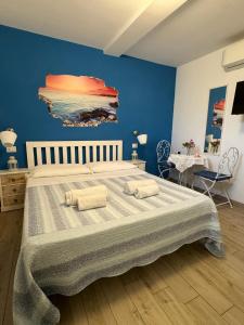 a bedroom with a large bed with a blue wall at B&B Villa Jasiga in Fregene
