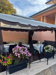 a patio with a table and chairs under an umbrella at B&B Villa Jasiga in Fregene