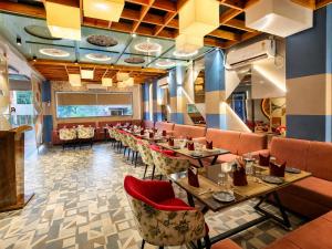a dining room with long tables and chairs at Aaditri Inn in Gorakhpur