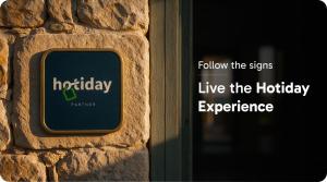 a sign on a brick wall with the words live the holiday experience at Hotiday Baja Sardinia Saline in Baja Sardinia +40 photos