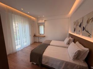 a bedroom with a bed and a large window at Rustemi in Sarandë