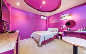 a purple room with a bed and a table at Hotel Fiona in Seoul