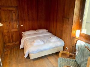 a bedroom with a bed with white sheets and wooden walls at Chalet Motta in Valtournenche