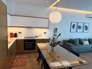 a kitchen and living room with a table and a couch at Rustemi in Sarandë