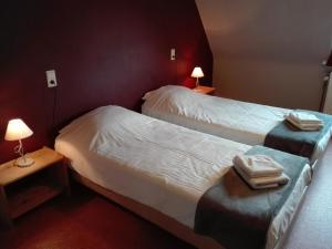 two beds in a hotel room with towels on them at Logies Het Maantje in De Panne