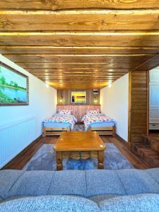 a room with two beds and a wooden ceiling at Ubytovanie u Richtára in Klokoč