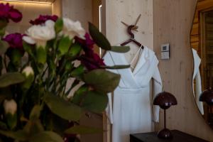 a white dress hanging on a wall next to a vase of flowers at Bella Lake Resort in Kuopio