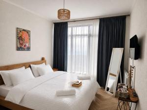 a bedroom with a large white bed and a window at Datvina Panorama Chalets Mravaldzali, Racha in Oni
