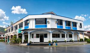 a white building with blue trim on a street at CZi BOUTIQUE HOTEL SG SIPUT in Sungai Siput