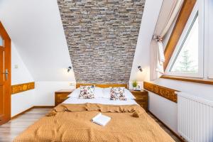 a bedroom with a brick wall and a bed at Willa Pod Wierchem in Bukowina Tatrzańska +93 photos