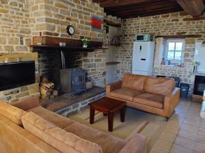 a living room with a couch and a fireplace at Orbigny Vakantiewoningen in Saint-Pierre-la-Vieille
