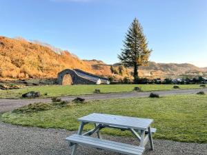 a picnic bench sitting in a field with a building at Innish - Uk38783 in Clachan