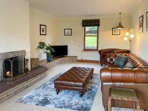 a living room with leather furniture and a fireplace at Innish - Uk38783 in Clachan +27 photos
