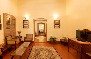 a large living room with a television and a living room at amã Stays & Trails - Fairholme Bungalow ,Yercaud in Yercaud