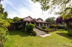 a house with a staircase in a yard at amã Stays & Trails - Fairholme Bungalow ,Yercaud in Yercaud