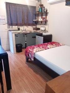 a room with a bed and a desk and a sink at Apartamentos Caimán 3 in Tortuguero