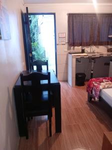 a room with a table and a chair and a kitchen at Apartamentos Caimán 3 in Tortuguero +7 photos
