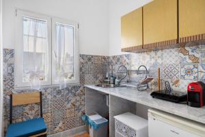 a kitchen with a sink and tiles on the wall at The Nice Bright House in Palermo