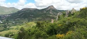 a view of a mountain with a tower on a hill at La glycine in Sahune