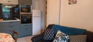 a living room with a couch and a kitchen at La glycine in Sahune