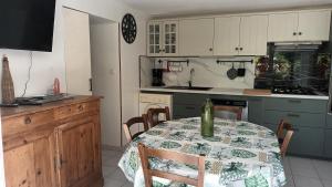 a kitchen with a table and a kitchen with a counter at La glycine in Sahune