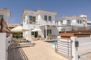 a large white house with a swimming pool at Fig Tree Beach villa Three in Protaras