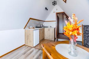 a kitchen with a vase of flowers on a table at Willa Pod Wierchem in Bukowina Tatrzańska