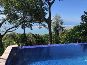 a blue swimming pool with a view of the ocean at Club Fred in Punta Mala
