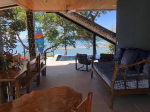 a room with benches and tables and a view of the water at Club Fred in Punta Mala