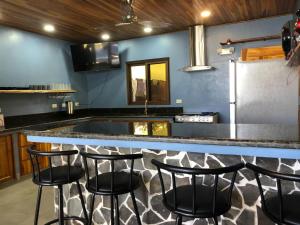 a kitchen with a counter with four bar stools at Club Fred in Punta Mala