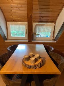 a wooden table in a room with two windows at To Huus bei Hanne  +4 photos