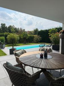 a patio with a table and chairs and a pool at Luxuriöse Fewo Schaffner in Warendorf
