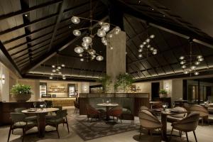 a restaurant with tables and chairs and a ceiling with chandeliers at The Ritz-Carlton Okinawa in Nago