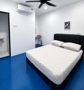 a bedroom with a bed with a ceiling fan at CZi BOUTIQUE HOTEL SG SIPUT in Sungai Siput