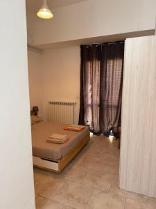 a bedroom with a bed and a window with curtains at Casina Toscana in Certaldo
