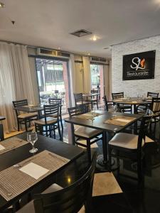 a dining room with tables and chairs in a restaurant at Guarulhos Flat Hotel in Guarulhos