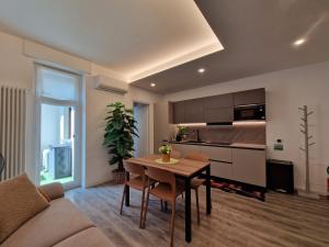 a living room with a table and a kitchen at Il Nido del Bernina 2 minuti dalla stazione Clessidra2 bilocale in Tirano