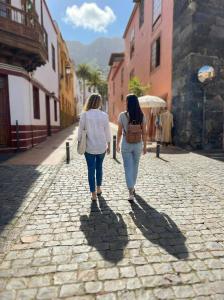two women walking down a cobblestone street at Casa Tradicional Canaria - Chico in Garachico