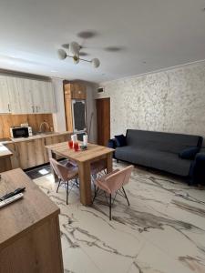 a living room with a couch and a table at Linen Tree Apartment in Băile Herculane