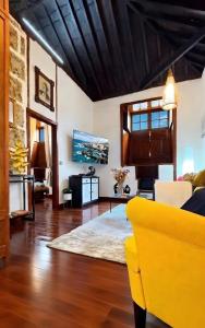a living room with a yellow couch at Casa Tradicional Canaria - Chico in Garachico