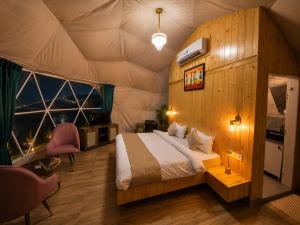 a bedroom with a bed in a tent at Glamp by Edge Resort Premium Luxury Domes with Mountain Views in Mussoorie